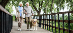 Senior Couple Walking Dog at Senior Living Community